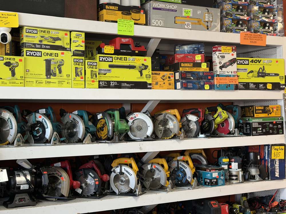 New-in-box power tools above rows of used circular saws at Deelz Tools Calgary